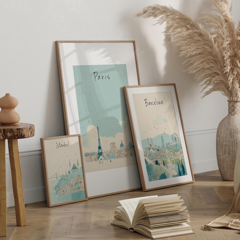 May include: Three framed art prints featuring watercolor illustrations of cityscapes. The prints showcase the skylines of Istanbul, Paris, and Barcelona, each labeled with its respective city name. The frames have a natural wood finish, and the artwork has a soft, muted color palette.