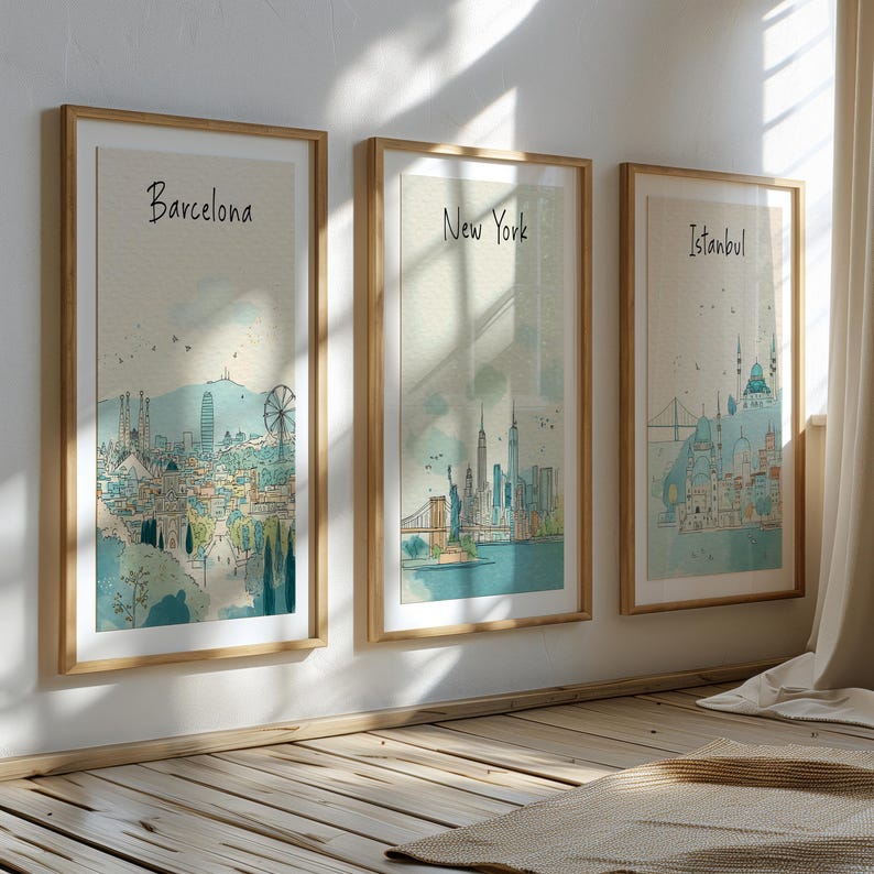 May include: Three framed art prints featuring cityscapes of Barcelona, New York, and Istanbul. Each print has a watercolor style with architectural details and the city name in a handwritten font. The frames are light wood.