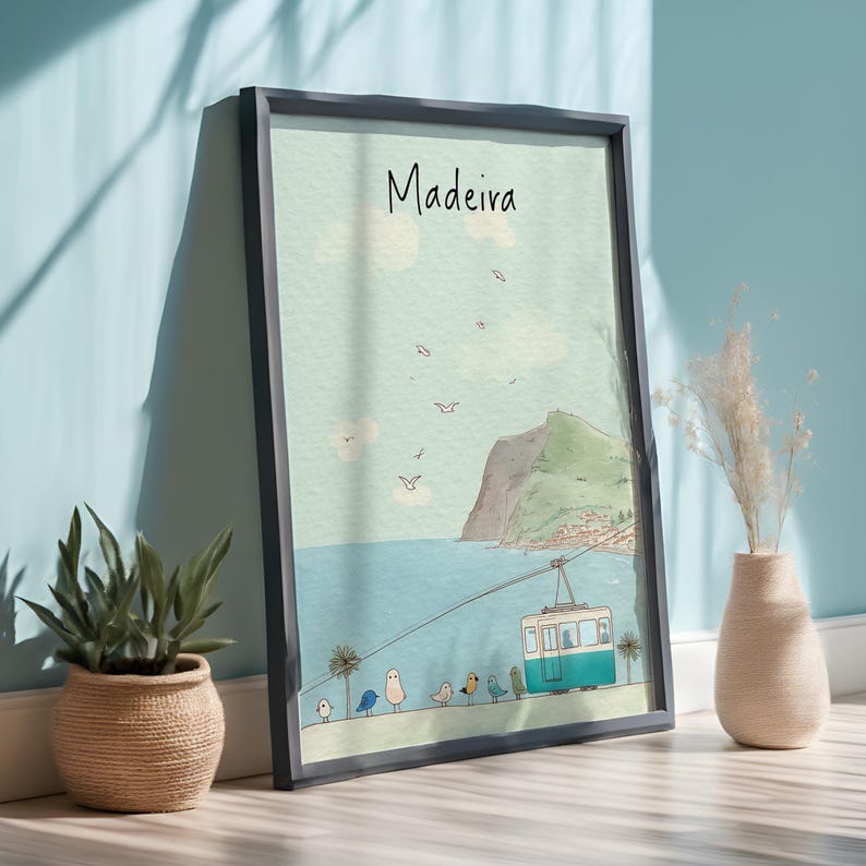 May include: Framed art print featuring a coastal scene with the word "Madeira" at the top. The artwork depicts a cable car, birds, and a mountain. The color palette includes shades of blue, green, and beige. A potted plant and a vase are in the foreground.