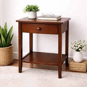 May include: A dark brown wooden nightstand with a single drawer and a lower shelf. A small potted plant, a book, and glasses rest on top. The nightstand is 24 inches tall and 18 inches wide.