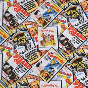 May include: A colorful fabric with a repeating pattern of vintage movie posters for the film "The Wizard of Oz". The posters feature the names of the actors, Judy Garland, Frank Morgan, Ray Bolger, Bert Lahr, and Jack Haley. The posters are in a variety of colors, including red, yellow, blue, and green.