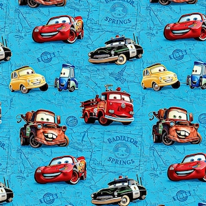 May include: A repeating pattern featuring various cartoon cars in red, yellow, blue, and black. The cars are set against a light blue background with a map design and the words "Radiator Springs".