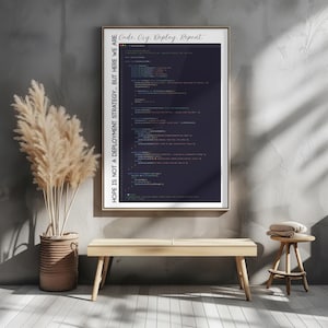 May include: A framed print with a dark blue background featuring lines of computer code. The top of the frame reads "Code. Cry. Deploy. Repeat." and the left side reads "HOPE IS NOT A DEPLOYMENT STRATEGY... BUT HERE WE ARE."