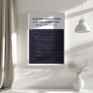 May include: A framed print with the text "CODE THAT DOESN'T CRASH, LOVE THAT DOESN'T FADE. No bugs. Just butterflies." The print also displays lines of code. The frame is white, and the background is a white wall.