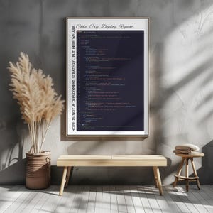 May include: A framed poster with the text "Code. Cry. Deploy. Repeat." and "HOPE IS NOT A DEPLOYMENT STRATEGY... BUT HERE WE ARE." The poster displays lines of code on a dark background. The image is displayed above a wooden bench and stool.