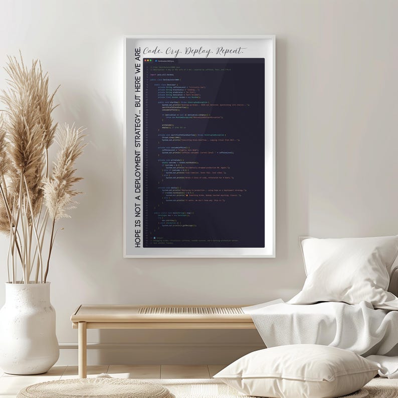 May include: A framed print with the text "Code. Cry. Deploy. Repeat" at the top and "Hope is not a deployment strategy... but here we are" on the side. The print features lines of code in various colours against a dark background.