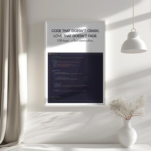 May include: A framed print with the text "CODE THAT DOESN'T CRASH, LOVE THAT DOESN'T FADE. No bugs. Just butterflies." The print displays a dark screen with code. The frame is white, set against a white wall.