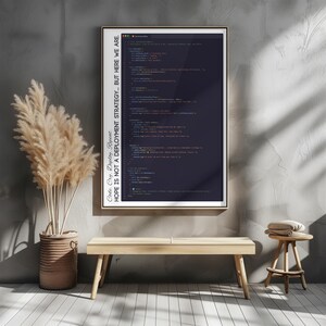 May include: A framed print featuring lines of code in a dark color scheme. The text on the print reads "Code. Cry. Deploy. Repeat. HOPE IS NOT A DEPLOYMENT STRATEGY... BUT HERE WE ARE." The print is displayed on a gray wall, with a wooden bench and a small stool in front.