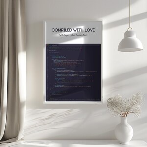 Pode incluir: Uma impress&atilde;o emoldurada com o texto "COMPILED WITH LOVE, No bugs. Just butterflies." A impress&atilde;o apresenta linhas de c&oacute;digo de computador em v&aacute;rias cores contra um fundo escuro. A impress&atilde;o &eacute; exibida em uma parede branca.