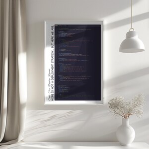 May include: A framed print featuring lines of computer code in various colors against a dark background. The text on the frame reads "Code. Cry. Deploy. Repeat. HOPE IS NOT A DEPLOYMENT STRATEGY... BUT HERE WE ARE."