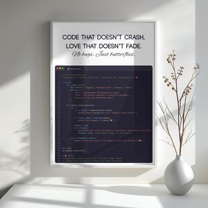 May include: A framed print with the text "CODE THAT DOESN'T CRASH, LOVE THAT DOESN'T FADE. No bugs. Just butterflies." The print also features computer code. A white vase with branches is to the right.