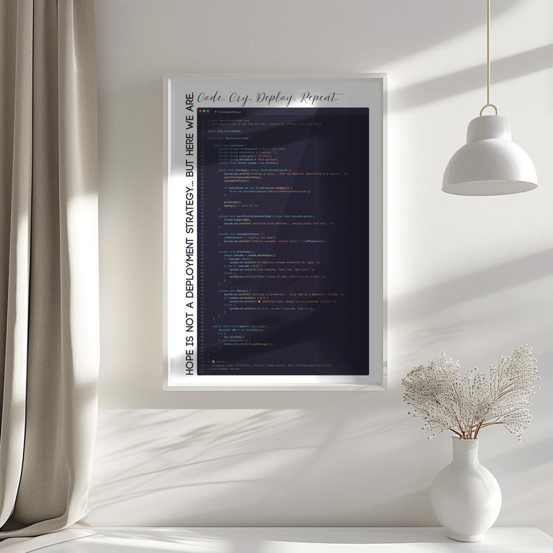 May include: A framed print with the text "Code. Cry. Deploy. Repeat." and "HOPE IS NOT A DEPLOYMENT STRATEGY... BUT HERE WE ARE." The print displays lines of code in various colors against a dark background. The frame is white.