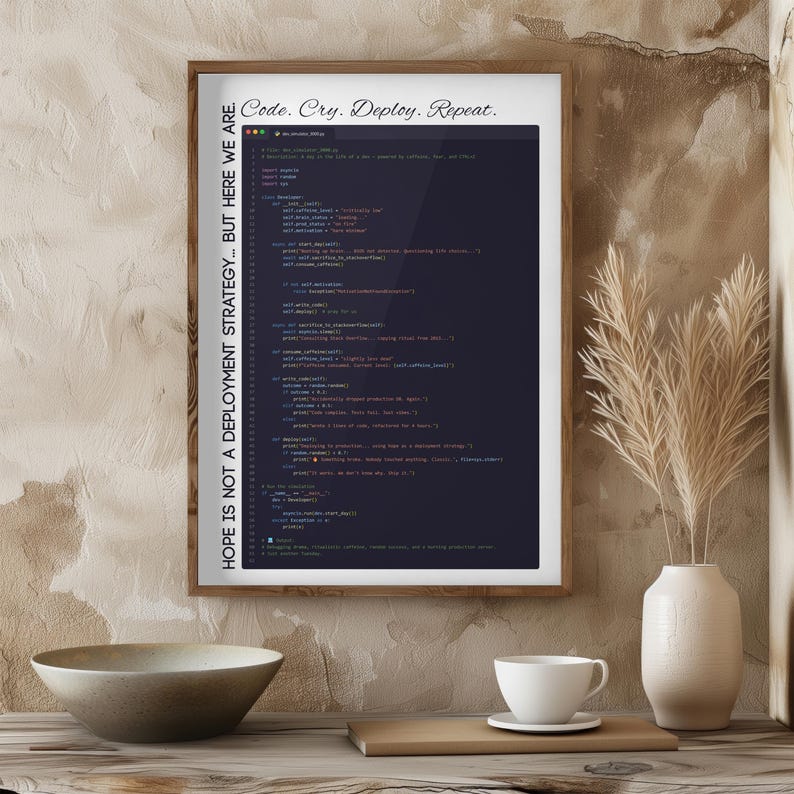 May include: A framed print with the text "Code. Cry. Deploy. Repeat." and "HOPE IS NOT A DEPLOYMENT STRATEGY... BUT HERE WE ARE." The print displays lines of code in a dark color. A white cup and bowl are in the foreground.