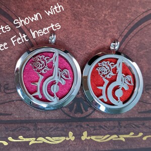 May include: Two silver-colored, round lockets with a rose and musical note design. One locket has a pink felt insert, the other has a red insert. The text "Lockets Shown with Free Felt Inserts" is visible.