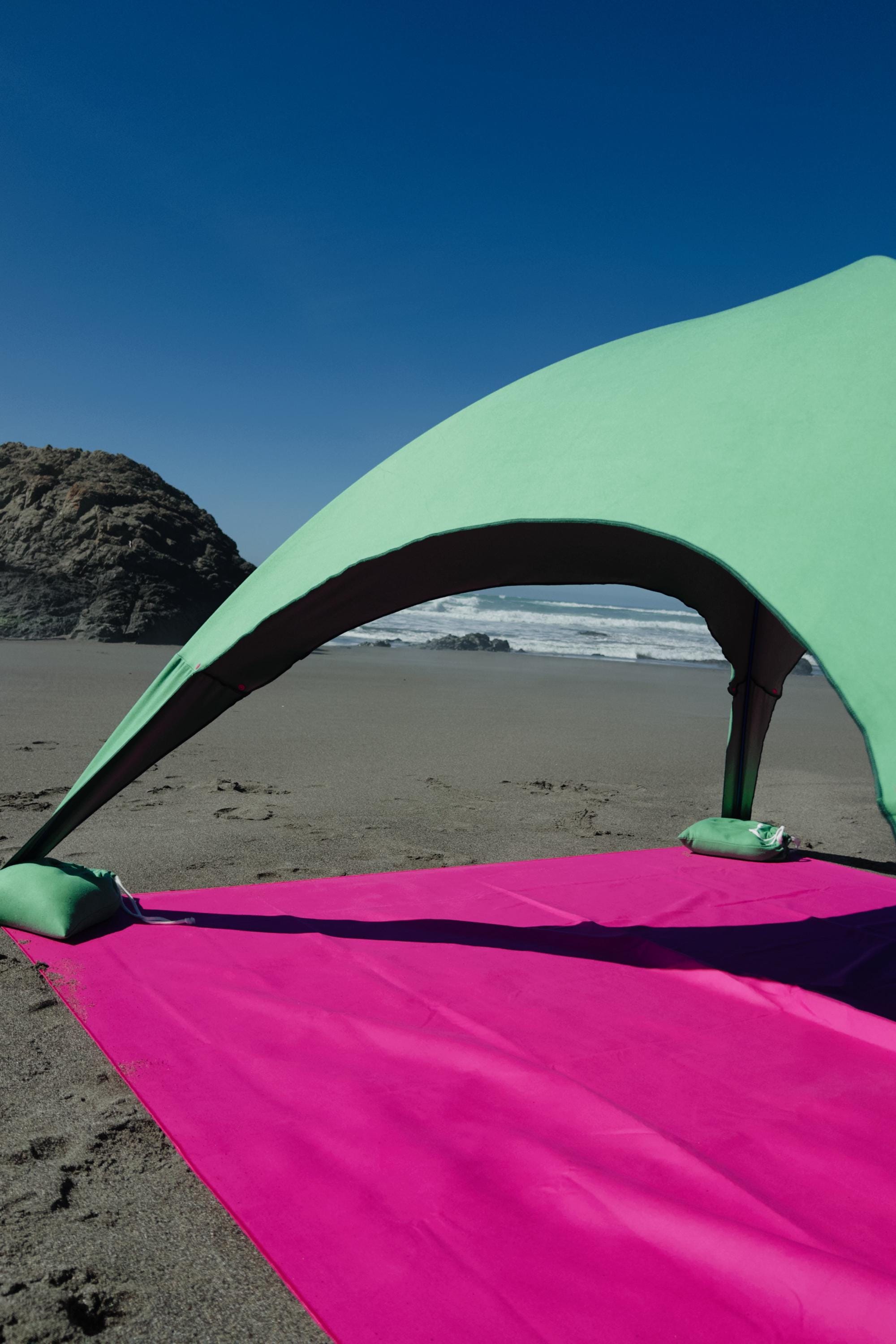 A portable beach tent perfect for sun protection and relaxation. Made from Suede microfiber towels. Pink & Green, more colors available.