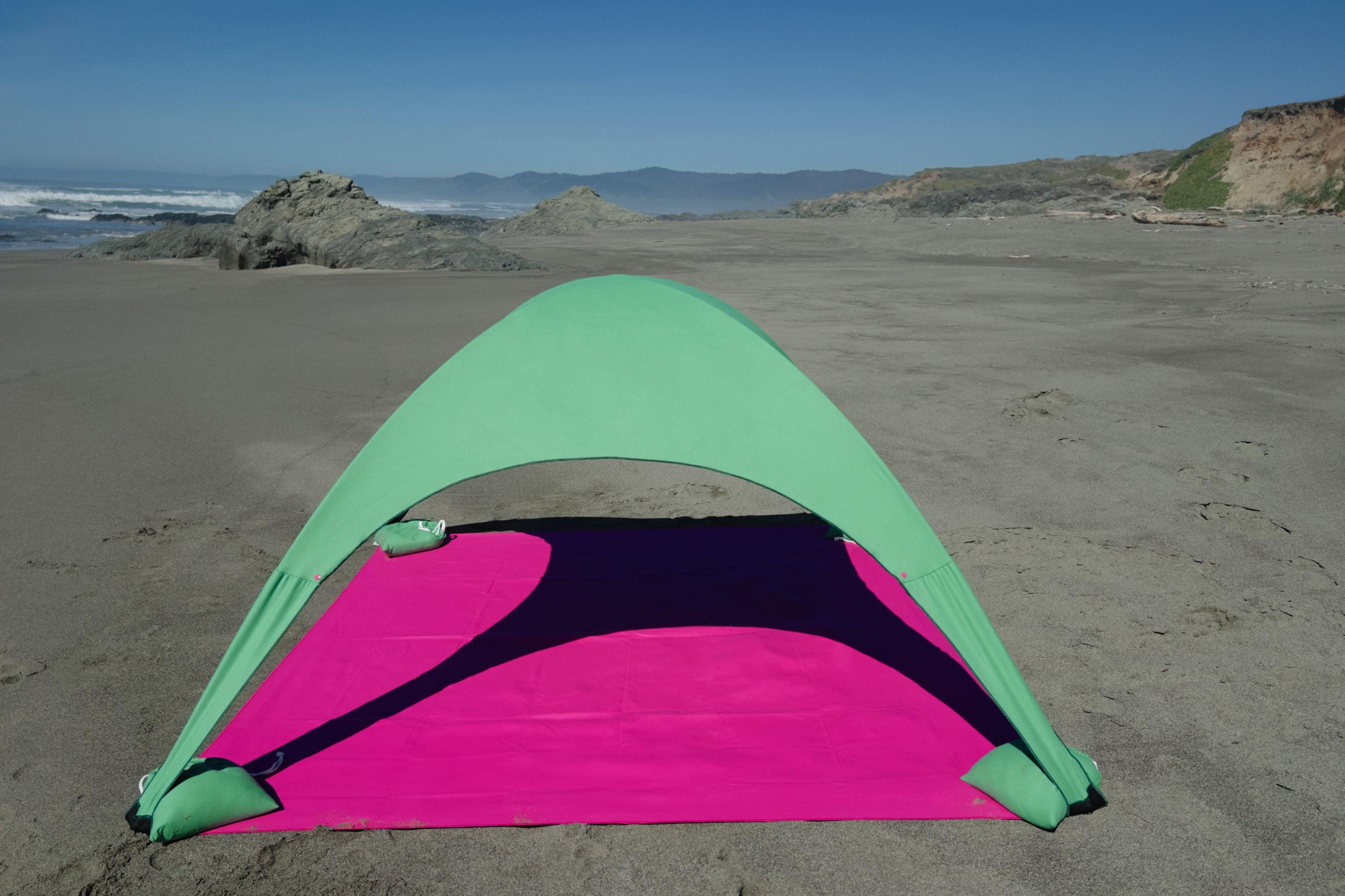 A portable beach tent perfect for sun protection and relaxation. Made from Suede microfiber towels. Pink & Green, more colors available.