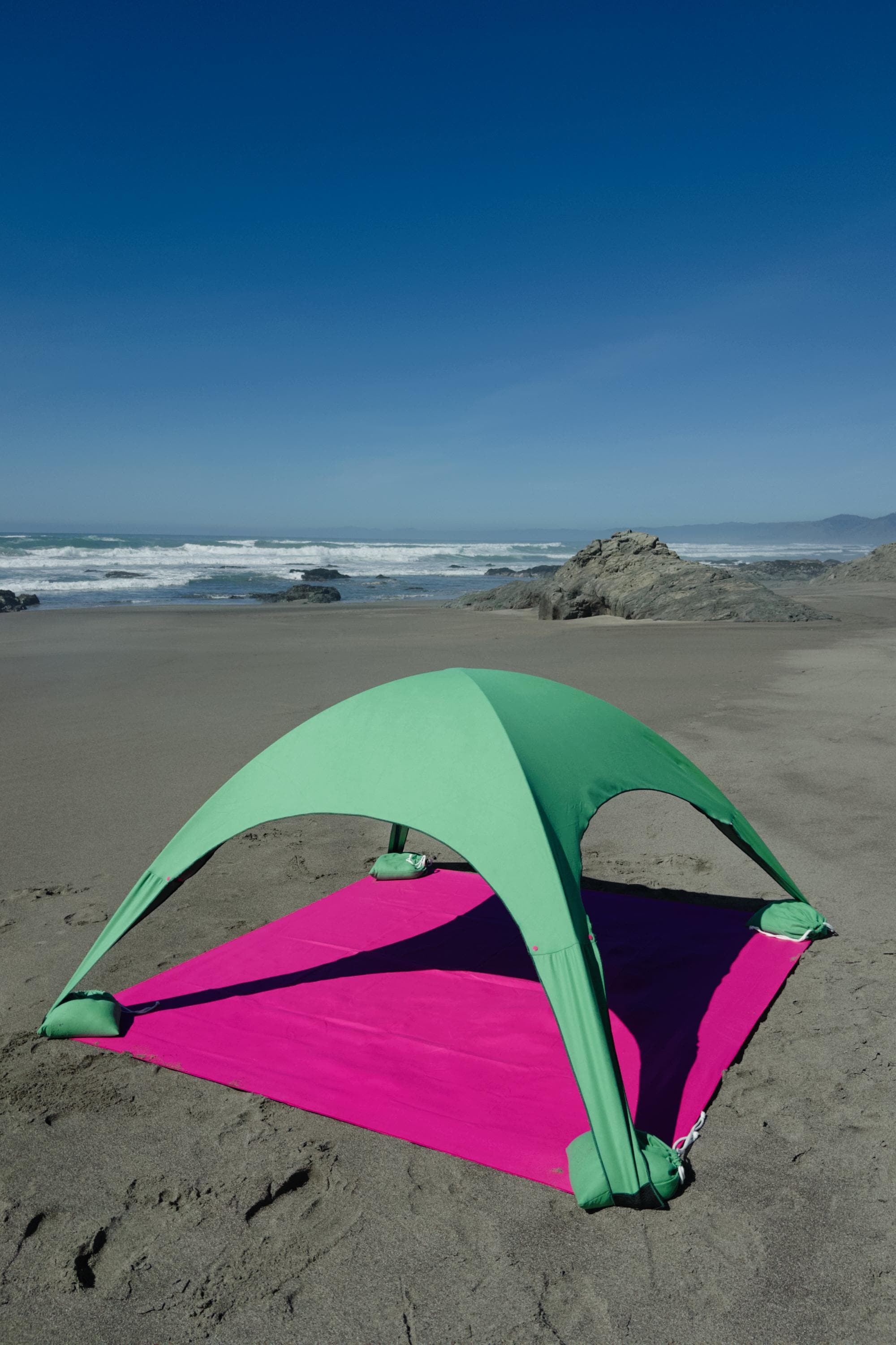A portable beach tent perfect for sun protection and relaxation. Made from Suede microfiber towels. Pink & Green, more colors available.