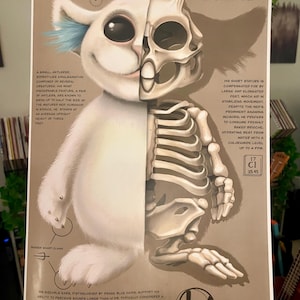 May include: A detailed anatomical illustration of a white, furry creature with blue ears and antlers, labeled "NED" (Neuro-Expansion Device). The creature's skeleton is visible on the right side of the image, with text describing its physical characteristics and diet.