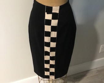 May include: A black skirt with a white and black checkered panel down the side.