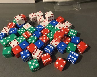 May include: A large pile of dice in red, blue, green, and white colors. The dice are all standard six-sided dice with white dots on each side.