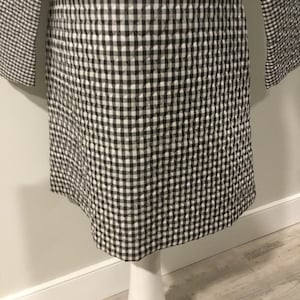 May include: A black and white gingham quilted dress with a red panel on the front.
