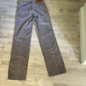 K&ouml;nnte beinhalten: Graue gestreifte Hose mit einem braunen Lederflicken auf der R&uuml;ckseite.