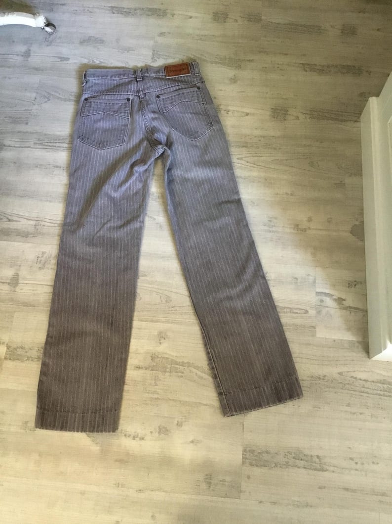 K&ouml;nnte beinhalten: Graue gestreifte Hose mit einem braunen Lederflicken auf der R&uuml;ckseite.