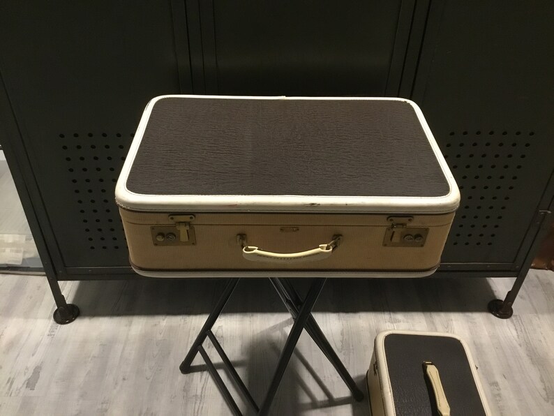 white suitcase with brown trim