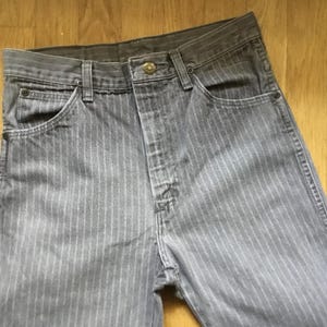 K&ouml;nnte beinhalten: Graue gestreifte Jeans mit Knopfleiste und einer einzigen Ges&auml;&szlig;tasche.