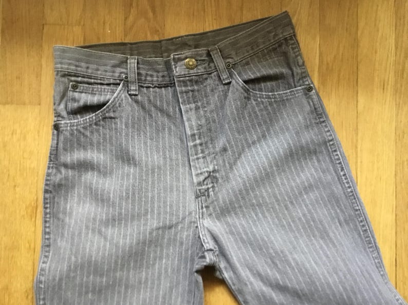 K&ouml;nnte beinhalten: Graue gestreifte Jeans mit Knopfleiste und einer einzigen Ges&auml;&szlig;tasche.