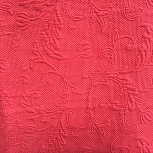 May include: A vibrant coral-red fabric featuring a raised, embossed floral pattern with intricate swirling vines and leaves. The material has a consistent, textured surface throughout, creating a monochromatic look with depth and dimension.
