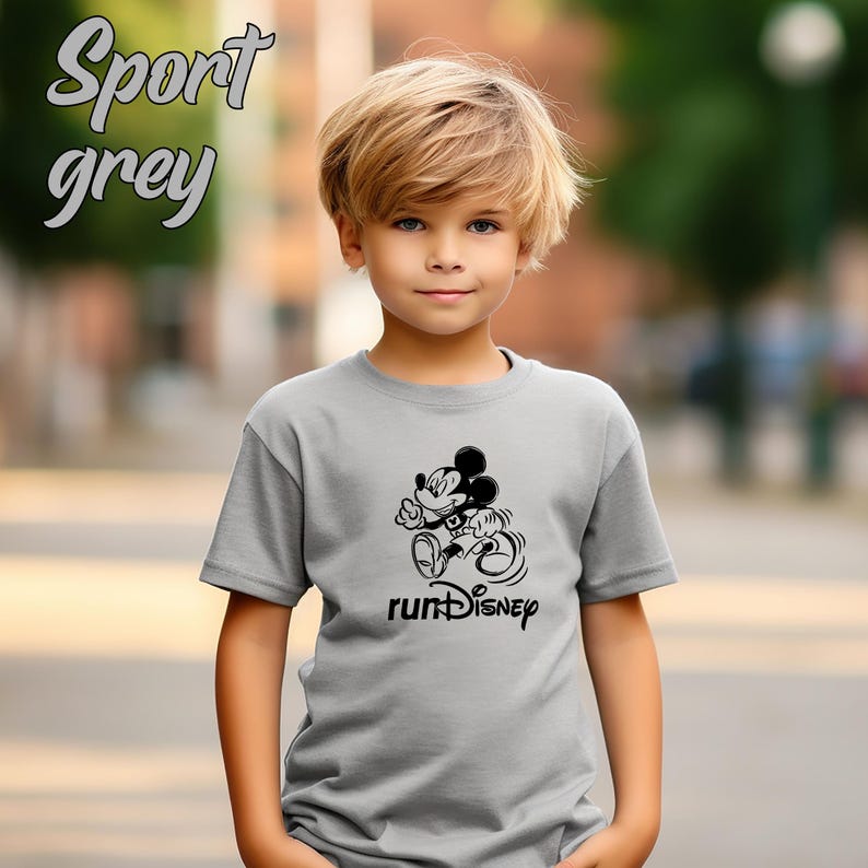May include: A light gray t-shirt with a black graphic of Mickey Mouse running, with the text "runDisney" below. The words "Sport grey" are written in cursive at the top left of the shirt.