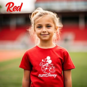 May include: A red t-shirt with a white graphic of Mickey Mouse and the text "runDisney". The word "Red" is written in red script in the upper left corner. The shirt is worn by a young girl with blonde hair.