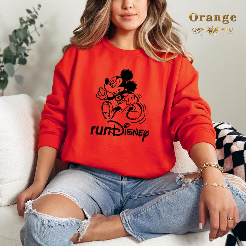 May include: A red sweatshirt featuring a black graphic of Mickey Mouse running and the text "runDisney".