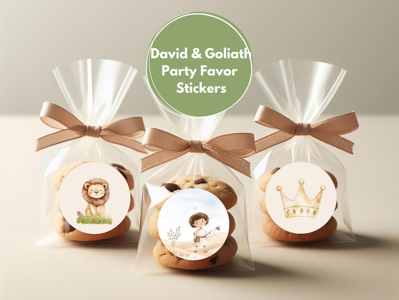 May include: Three clear cellophane bags with brown ribbon ties, each containing cookies and a round sticker. The stickers feature illustrations of a lion, a boy with a slingshot, and a crown. The green circle sticker on top reads "David & Goliath Party Favor Stickers".