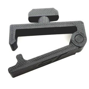 May include: A black capo with a textured surface. The capo has a lever arm and a screw adjustment. The capo is designed to clamp onto the neck of a stringed instrument.