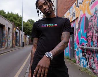 May include: A person wearing a black t-shirt with a rainbow gradient "SATOSHI" graphic. The person is wearing a silver watch on their left wrist.