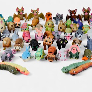 a large number of colorful toy animals, including various types of insects, such as caterpillars, bats, and other creatures, arranged in a playful and diverse manner.