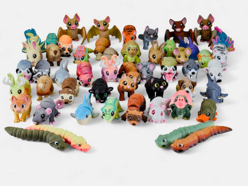 a large number of colorful toy animals, including various types of insects, such as caterpillars, bats, and other creatures, arranged in a playful and diverse manner.
