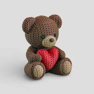 A brown teddy bear holding a red heart-shaped object.