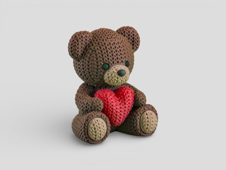 A brown teddy bear holding a red heart-shaped object.