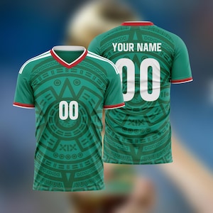May include: Green soccer jersey with white accents, a red collar, and the number "00" in white. The jersey features a geometric design in dark green and the text "YOUR NAME" on the back.