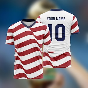 May include: A white and red striped soccer jersey with a V-neck collar. The jersey has the number 10 on the back, along with the text "YOUR NAME". The stripes have a wavy design.