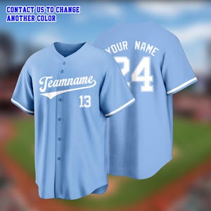 May include: Light blue baseball jersey with white accents. The front features the word "Teamname" and the number 13 in white. The back displays "Your Name" and the number 24. The text "CONTACT US TO CHANGE ANOTHER COLOR" is at the top.