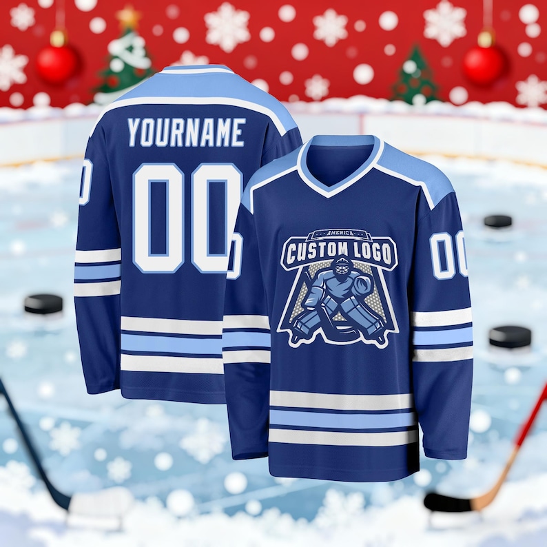 May include: Two navy blue hockey jerseys with light blue and white accents. One jersey displays the text "YOURNAME" and the number "00". The other jersey features a custom logo and the number "00". Both jerseys have a V-neck design.