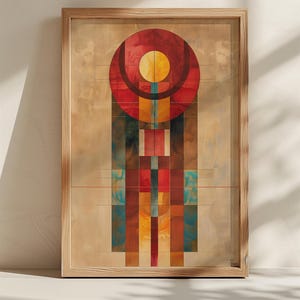 Op de afbeelding: Abstracte kunstafdruk in een houten lijst. Het kunstwerk toont een geometrisch ontwerp met een grote rode cirkel bovenaan, een gele cirkel in het midden en een verticale opstelling van kleurrijke rechthoeken in tinten rood, blauw en geel.