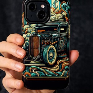 Pode incluir: Capa de telefone preta com uma ilustração colorida de um carro hot rod vintage. O design inclui linhas onduladas em tons de laranja, verde-azulado e amarelo, com uma porta com aspecto de madeira e pneus de faixa branca. A capa tem um acabamento brilhante.