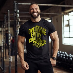 May include: Black t-shirt with yellow text that reads "Wrestlers Overcome Every Challenge Never Settle." The shirt is short-sleeved and worn by a person in a gym setting. The person is smiling and wearing a black watch.