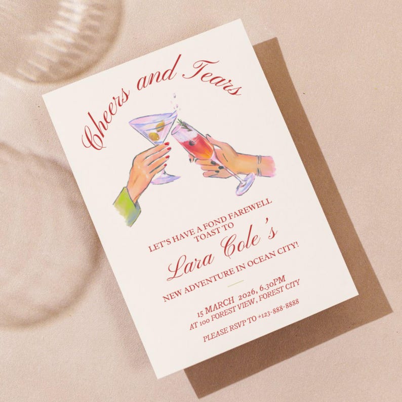 Op de afbeelding: Een witte kaart met rode tekst die "Cheers and Tears" en "Let's have a fond farewell toast to Lara Cole's new adventure in Ocean City!" luidt. De kaart bevat ook een afbeelding van twee handen die cocktailglazen omhoog houden.