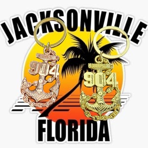 Puede incluir: Dos llaveros con diseño de ancla y el número "904" se muestran. Los llaveros son de color oro y cobre, sobre un fondo de puesta de sol con una silueta de palmera. Las palabras "JACKSONVILLE FLORIDA" están arriba y abajo.